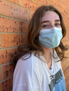 Young girl wearing a mask due to COVID-19 by Cara Lehr