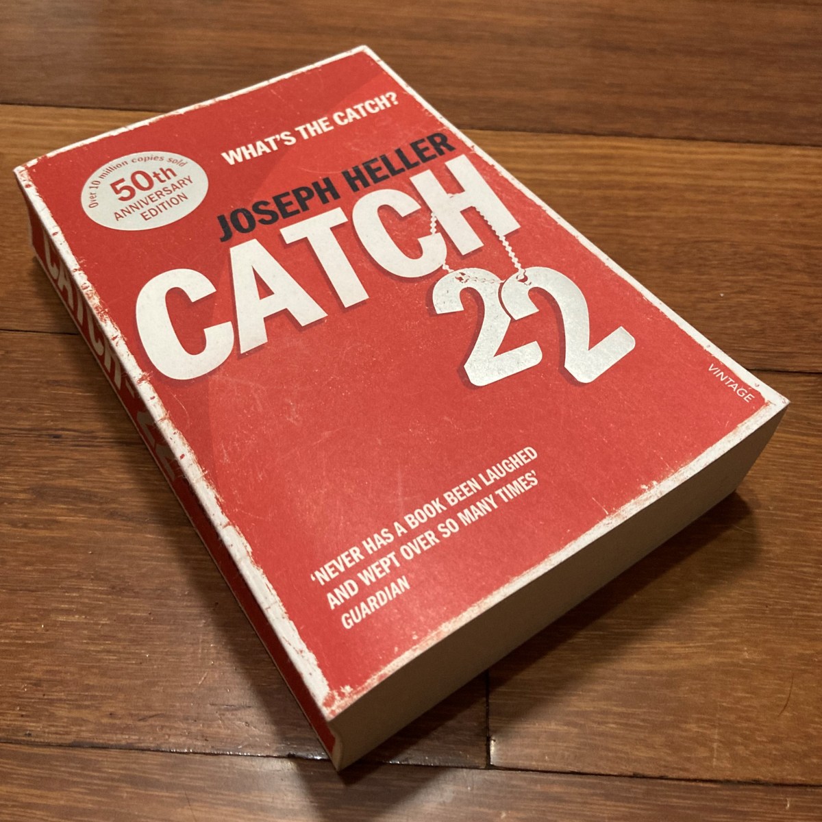 The novel Catch-22 by Joseph Heller, against a wood backdrop.