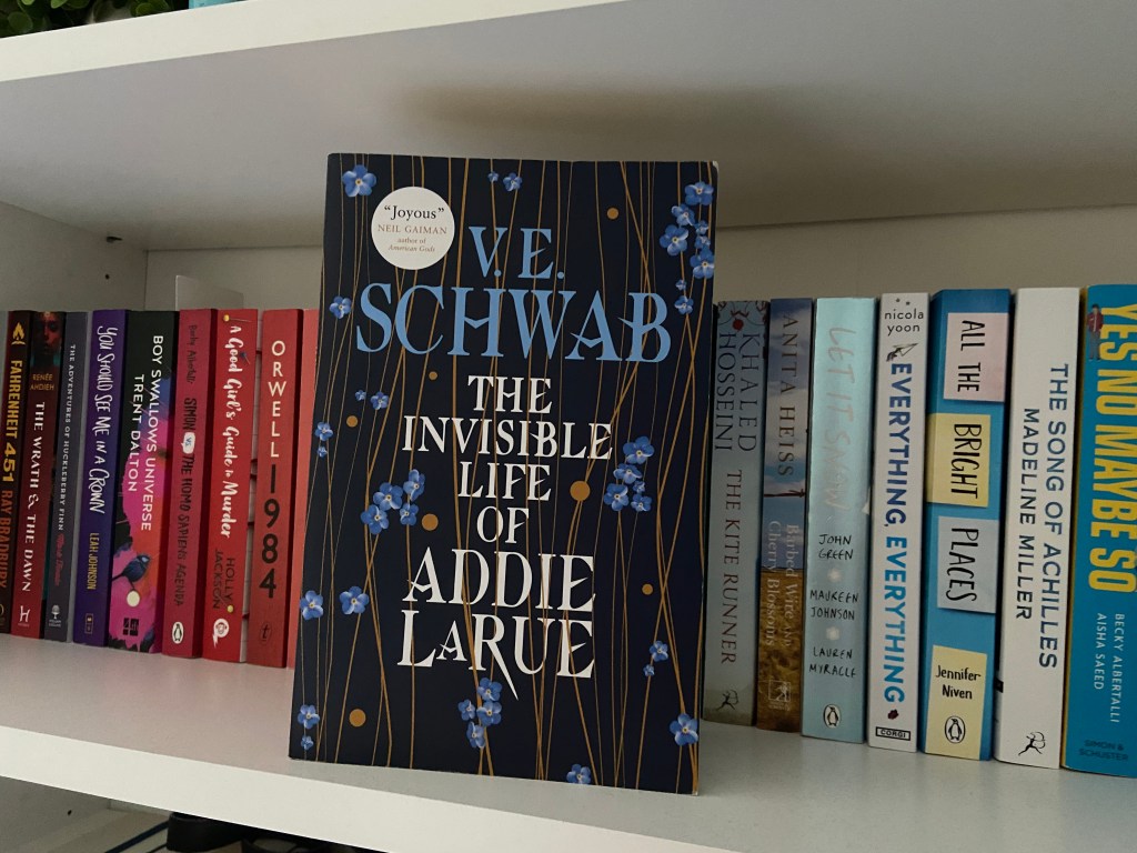 The Invisible Life of Addie LaRue on a bookshelf in front of other books