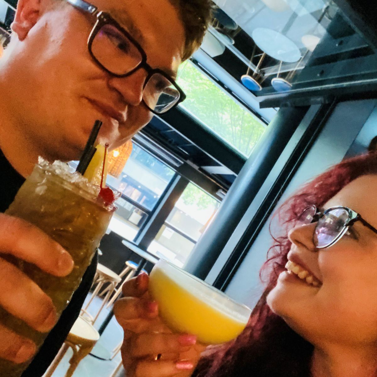 Couple looking at each other, smiling and holding a cocktail each