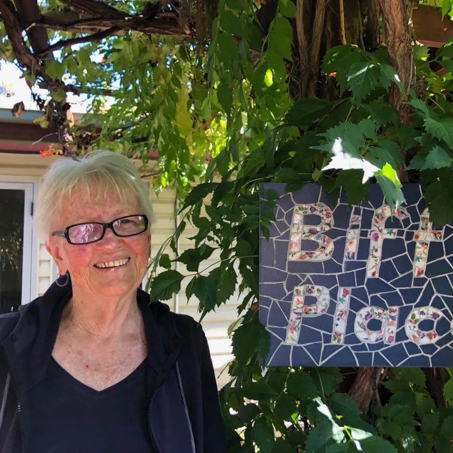 Biff Ward standing in front of a garden sign that reads 'Biff's Place'
