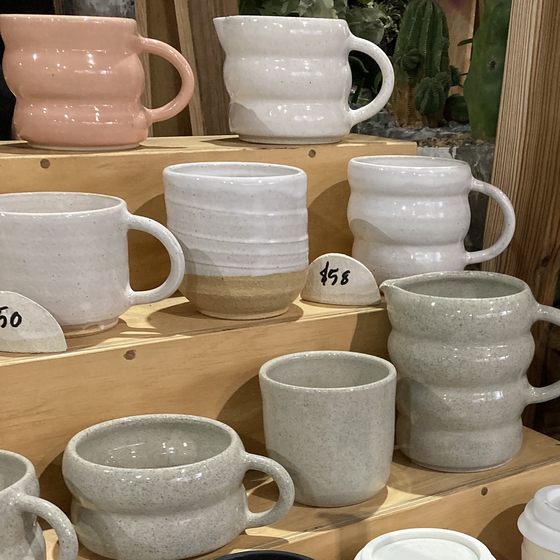 Ceramic homeware mugs. Shaped in a circular design. White, pink and grey in colour. 