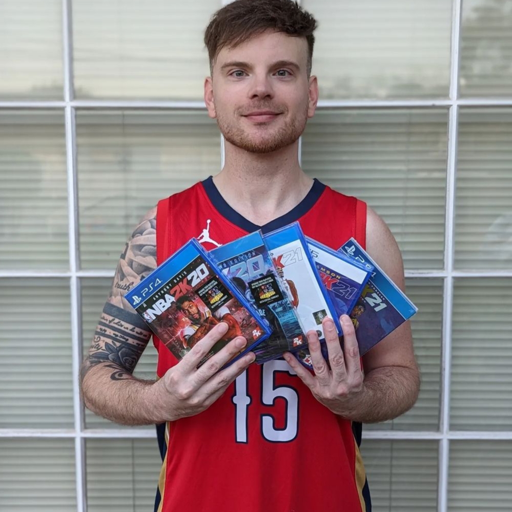 Nate holding up different copies of 2K and looking straight into the camera