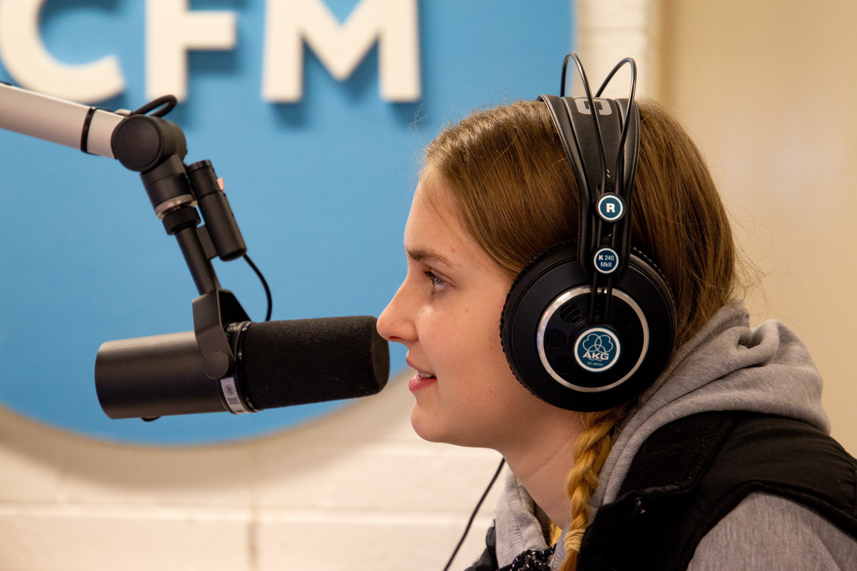 A student speaking into a microphone in the UCFM studio