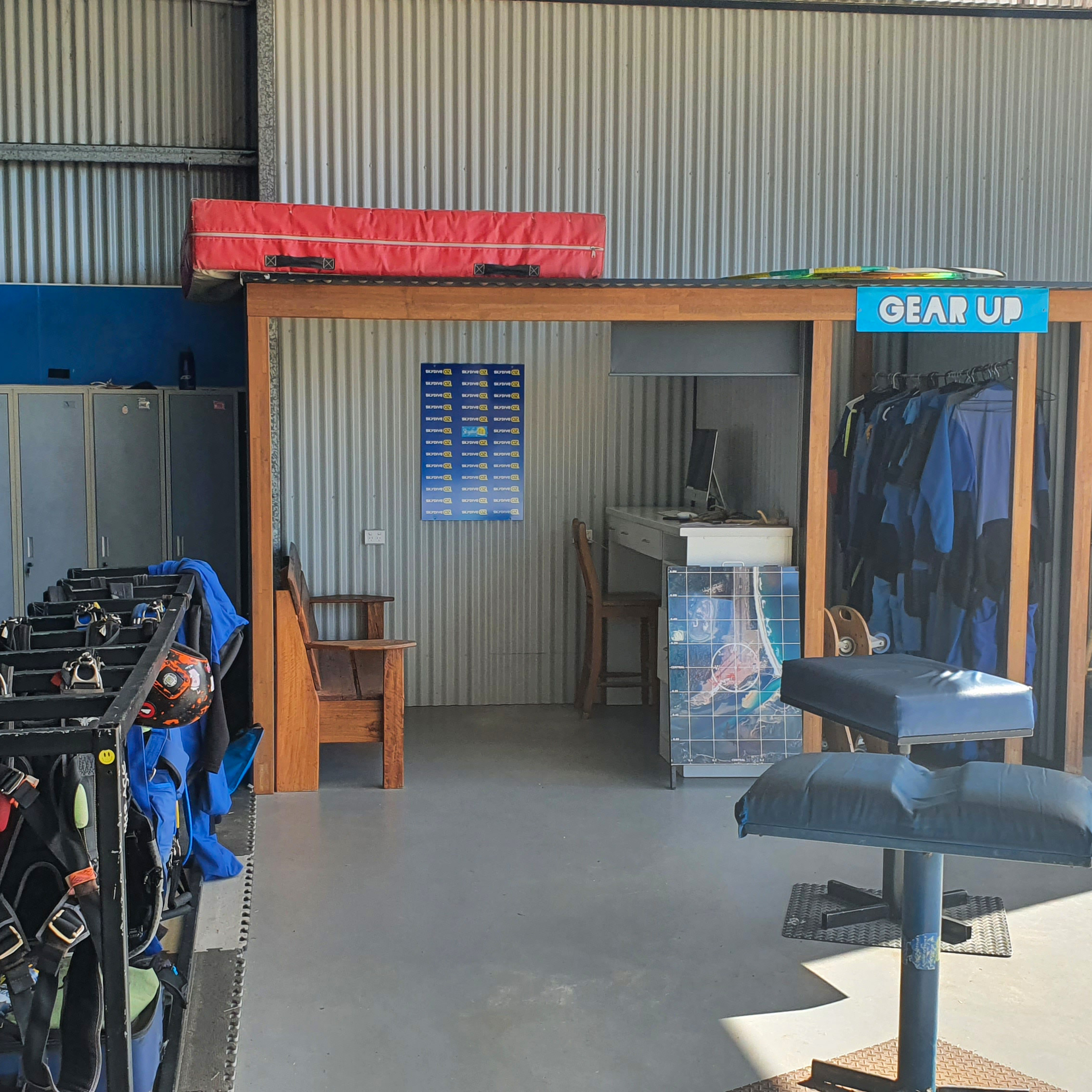 Gear up station at Skydive Oz with jumpsuits and rigs.