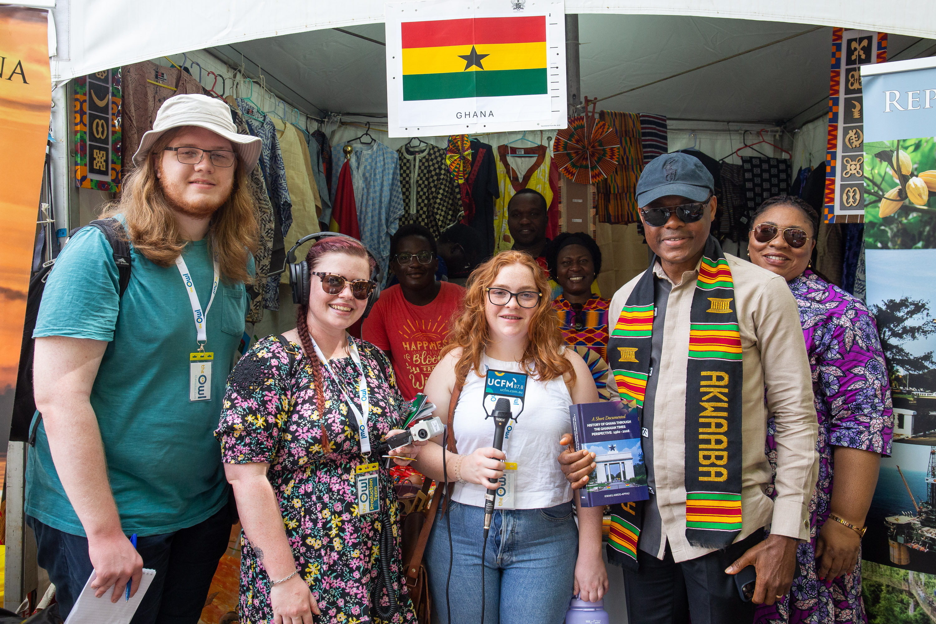 Ben, Lila, Molly and five stallholders posing in front of the Ghana stall