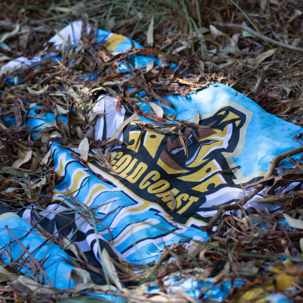 Gold Coast Titans flag half buried in the dirt