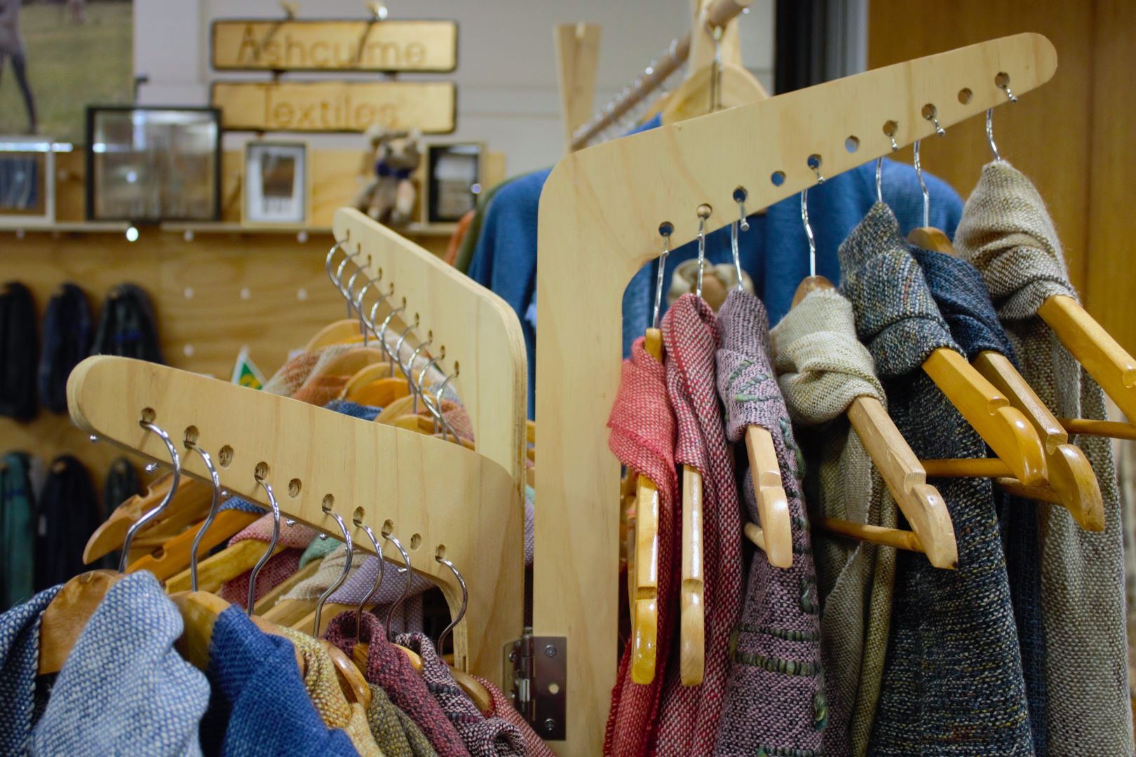 Woven clothes displayed on a wooden rack. 