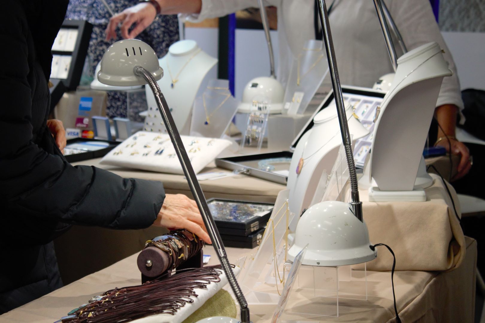 Person browsing at a market stall selling opal jewellery