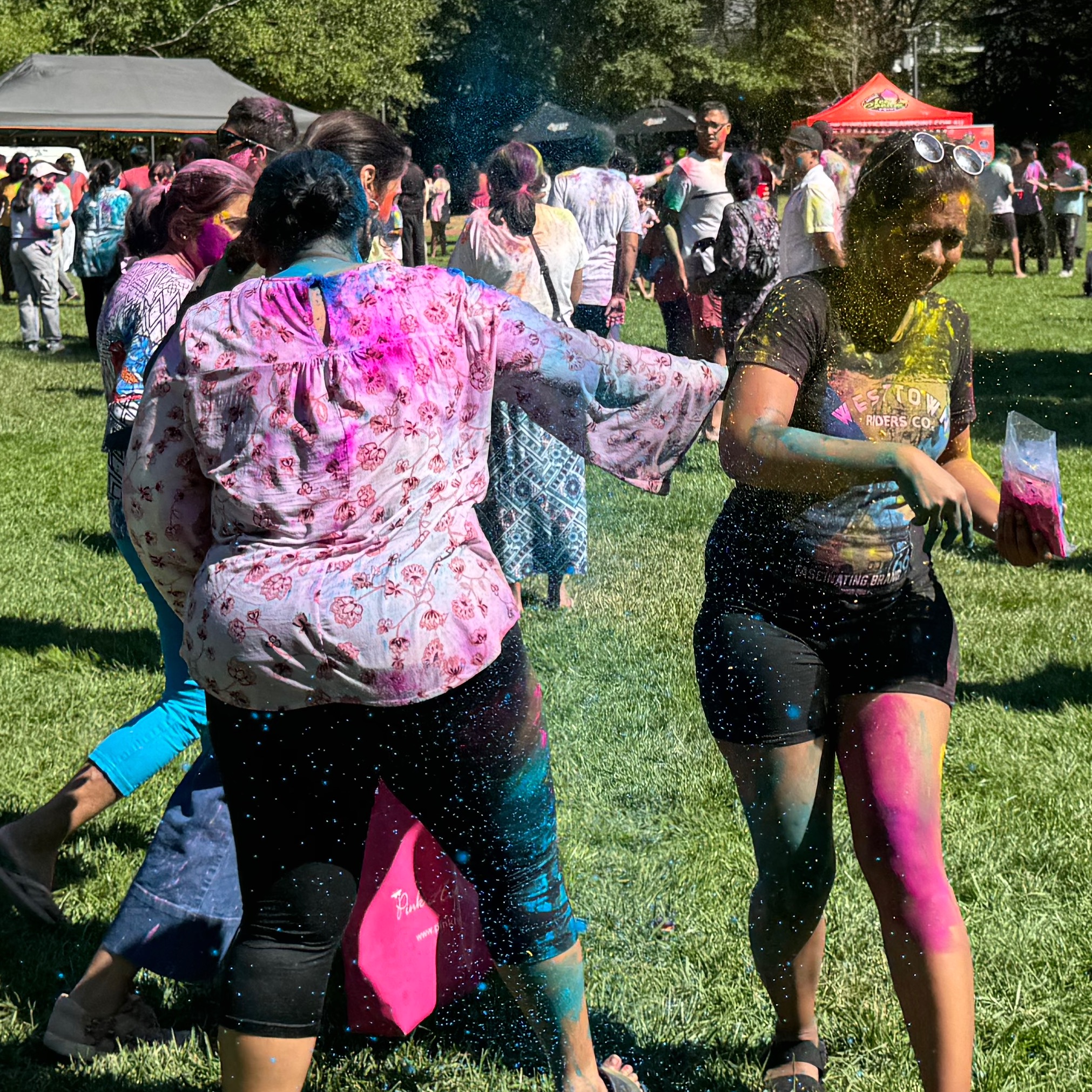 woman throwing colour on another woman with eyes closed