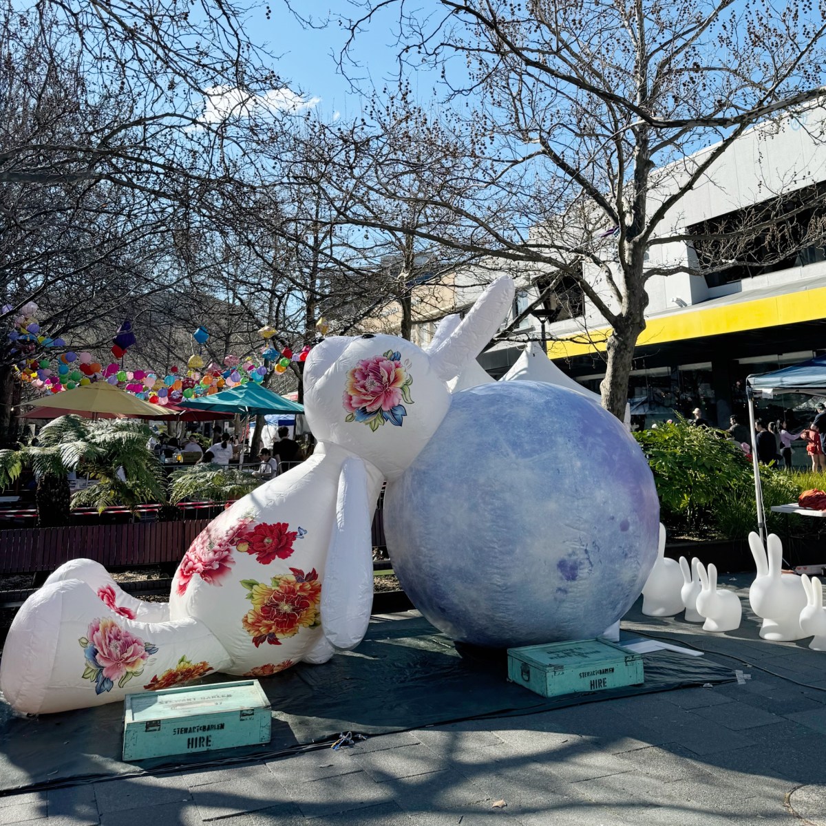 inflatable bunny leaning on big blue moon on ground