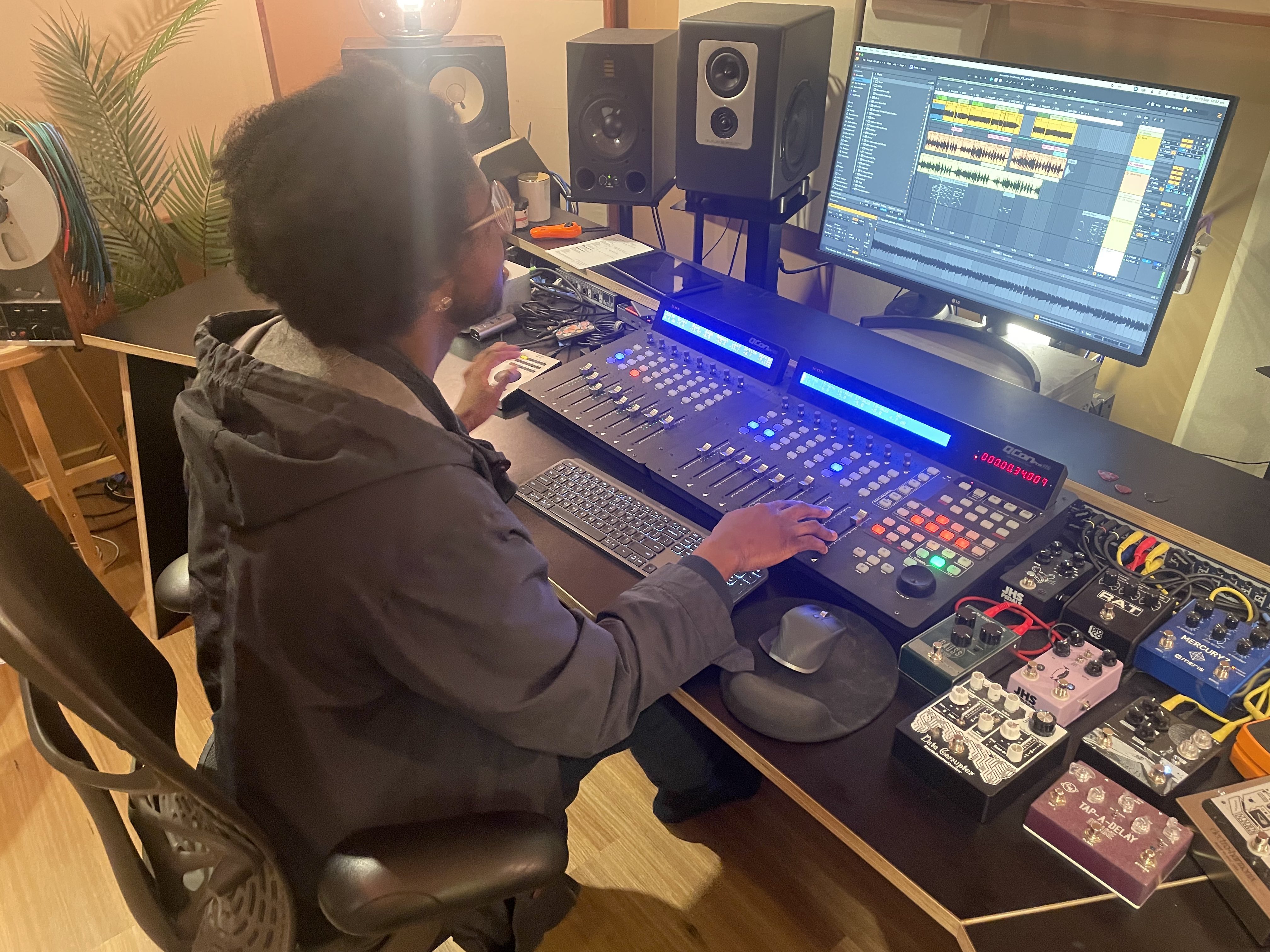 Man editing music at a recording desk