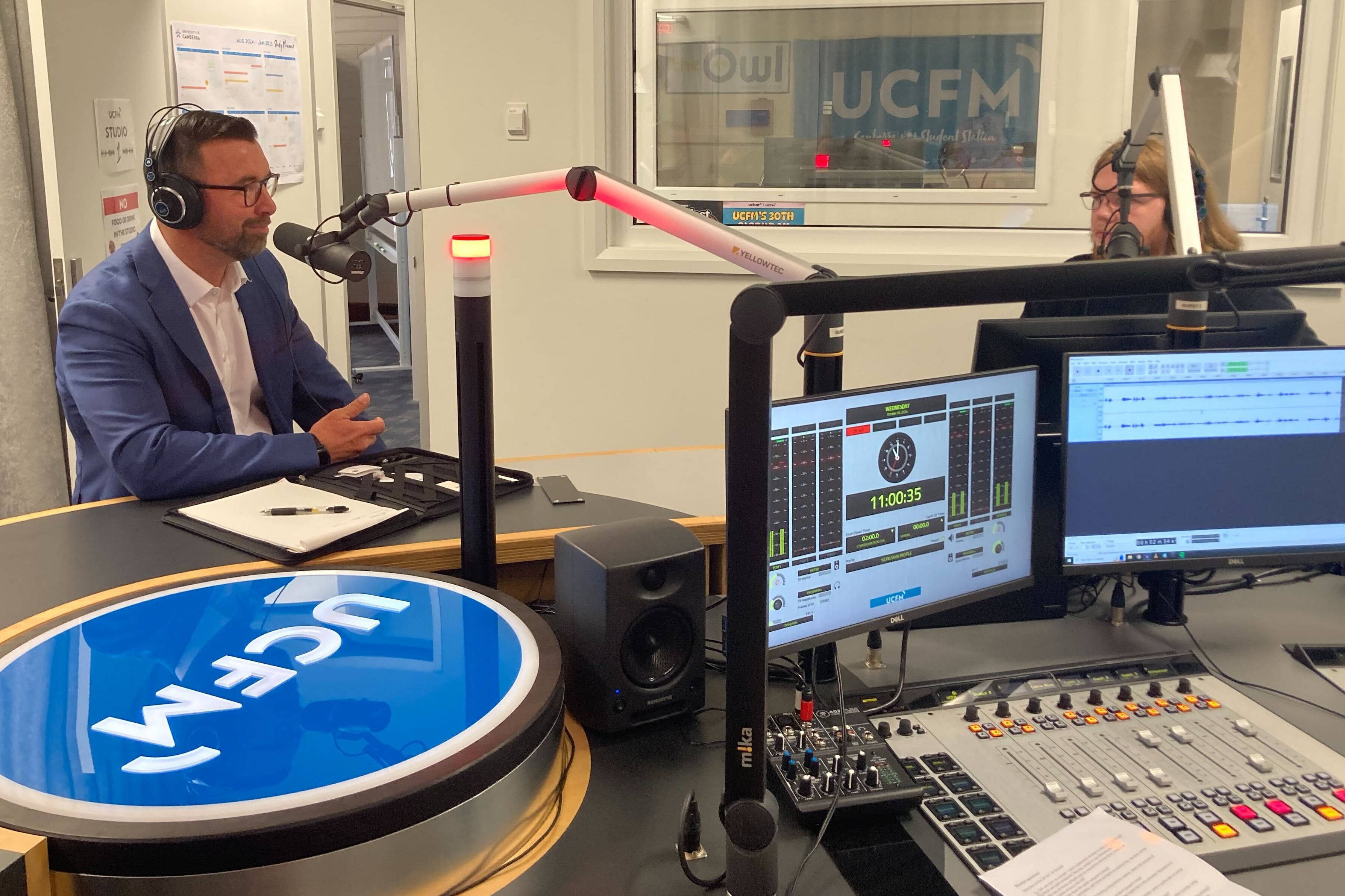 Mike Sykes behind the mic in the UCFM studio beside Ben Devlin.