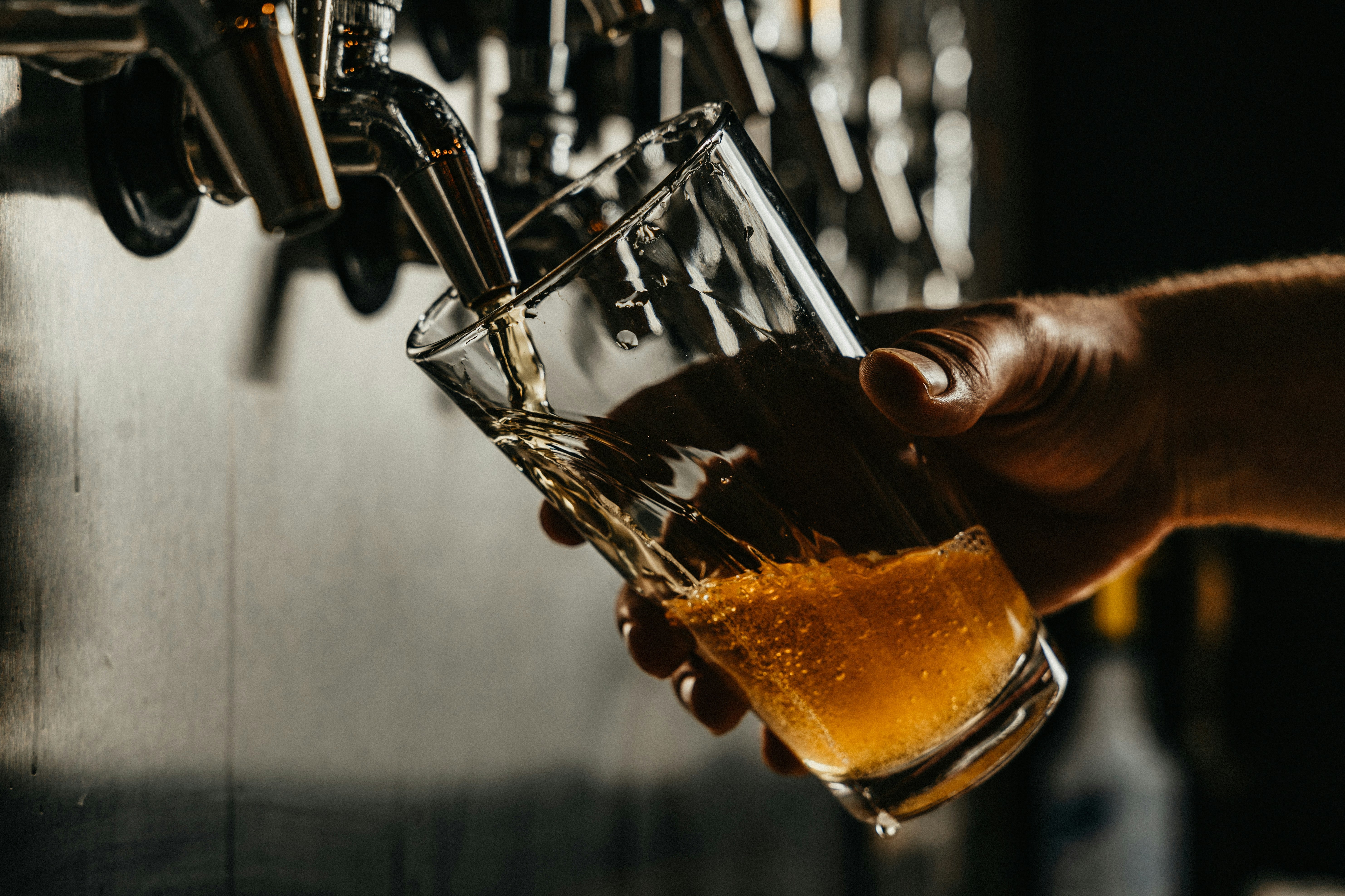 A glass of beer being poured from a tap