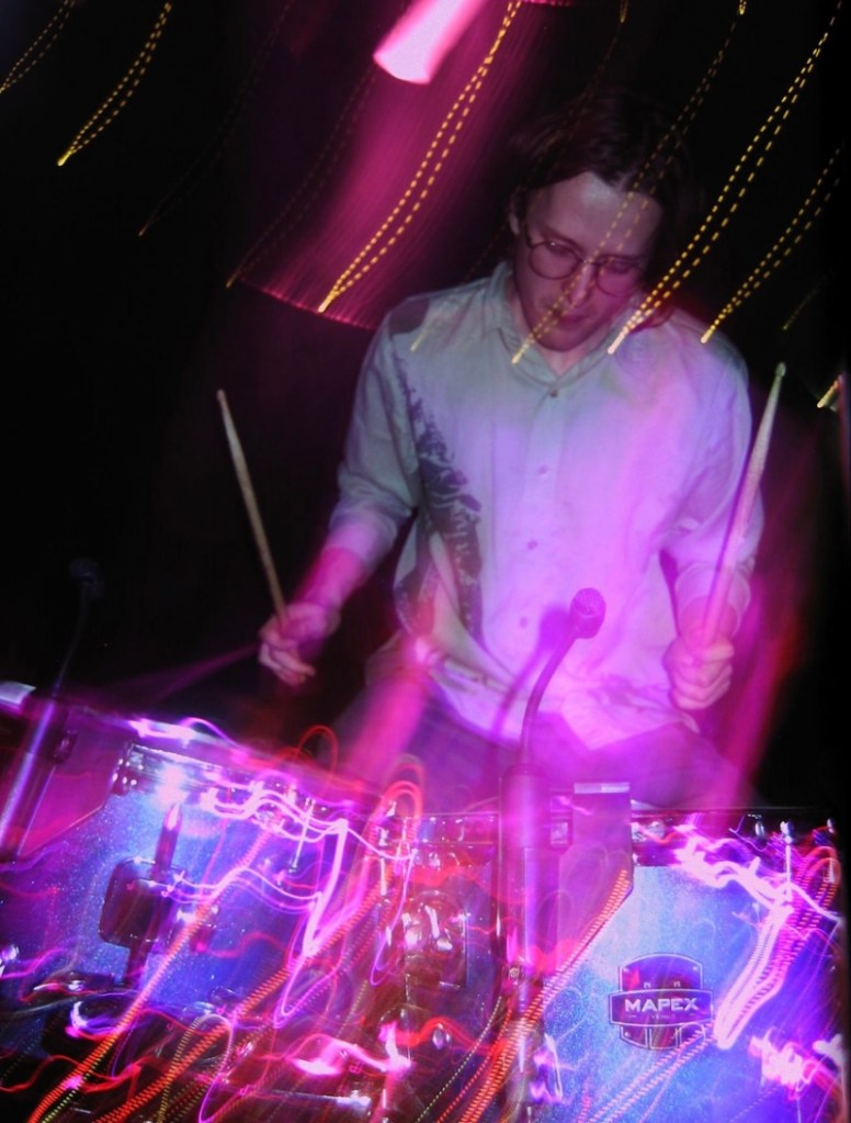Jasper Newbury, drummer of DSM6, performing on stage
