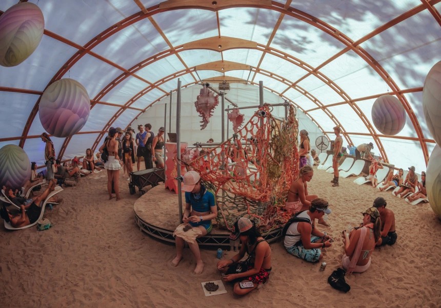 People sitting under structure looking at art installation