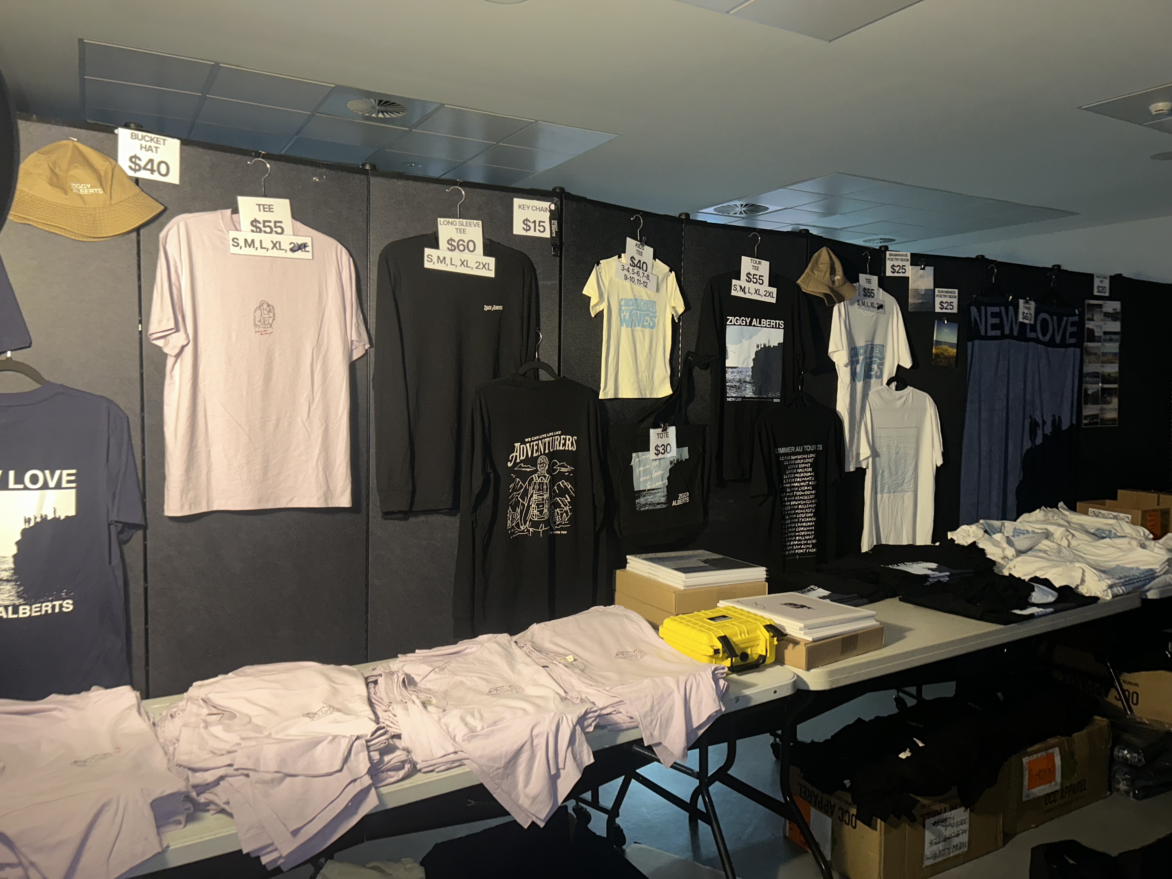 Merchandise booth with selection of t-shirts, hats, tote-bags