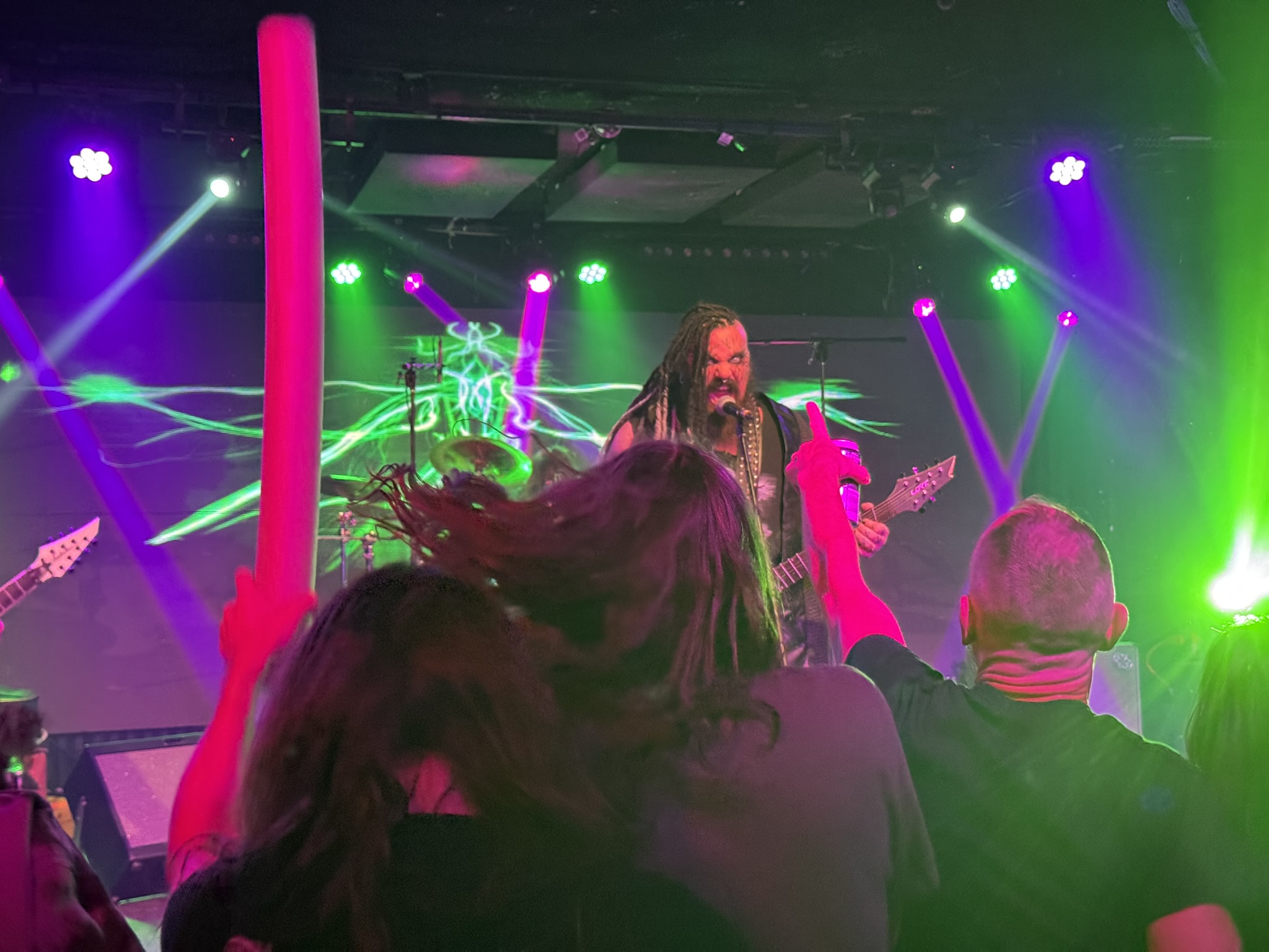 Pyrefly perform on stage, with an audience member wielding a pool noodle in the foreground
