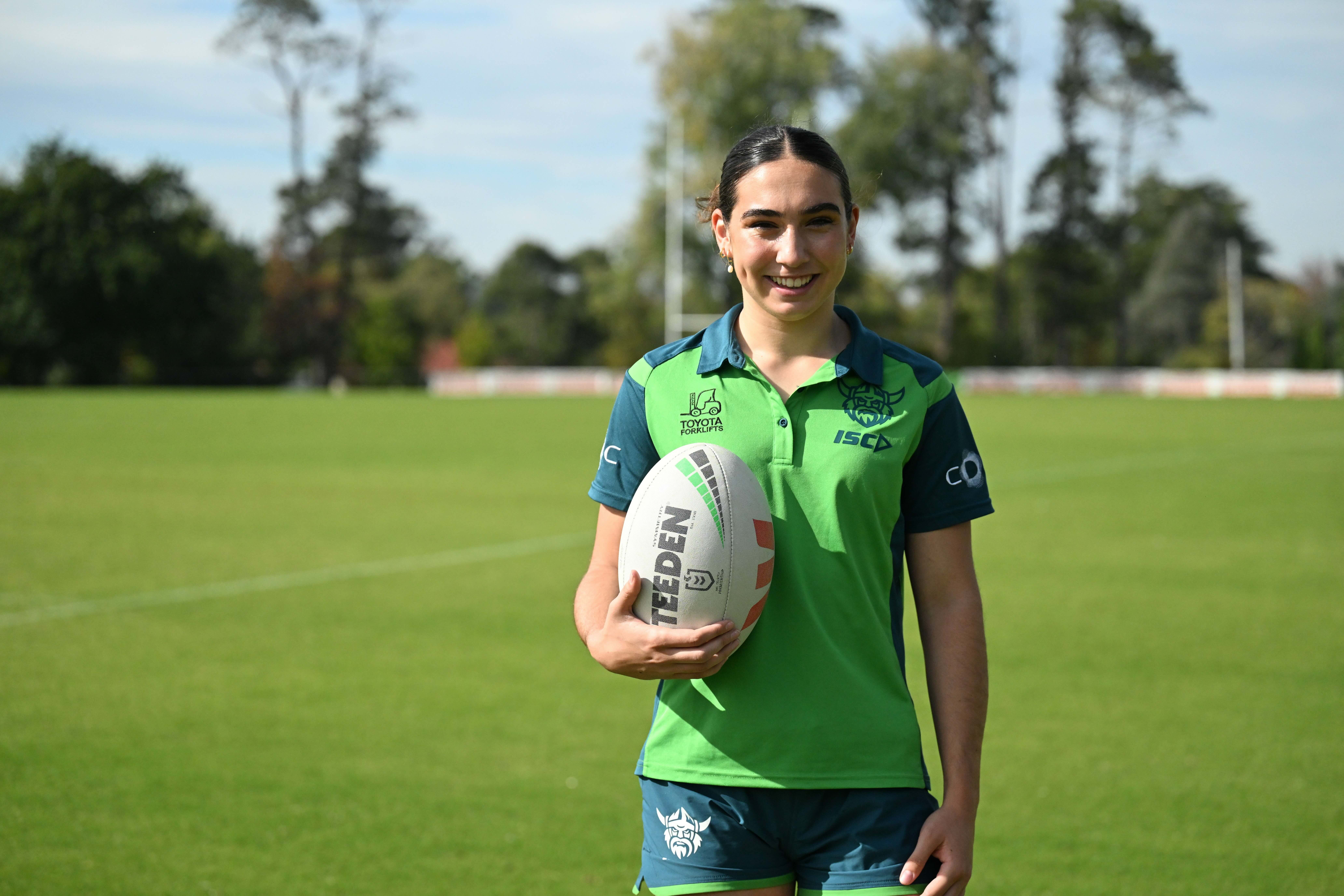 Elise Simpson posing with a football at the Canberra Raiders training centre.