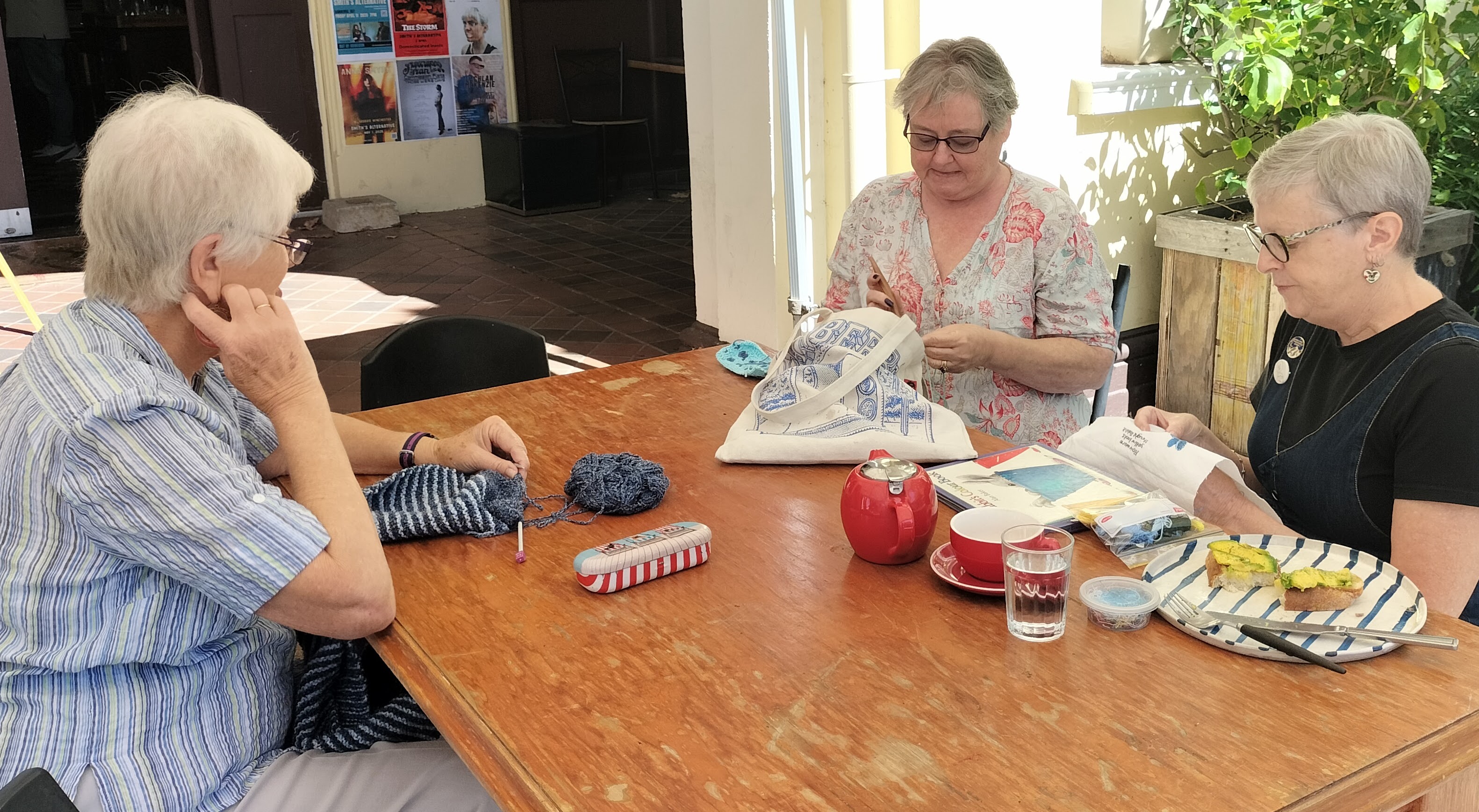 Three women at a table doing some crafts