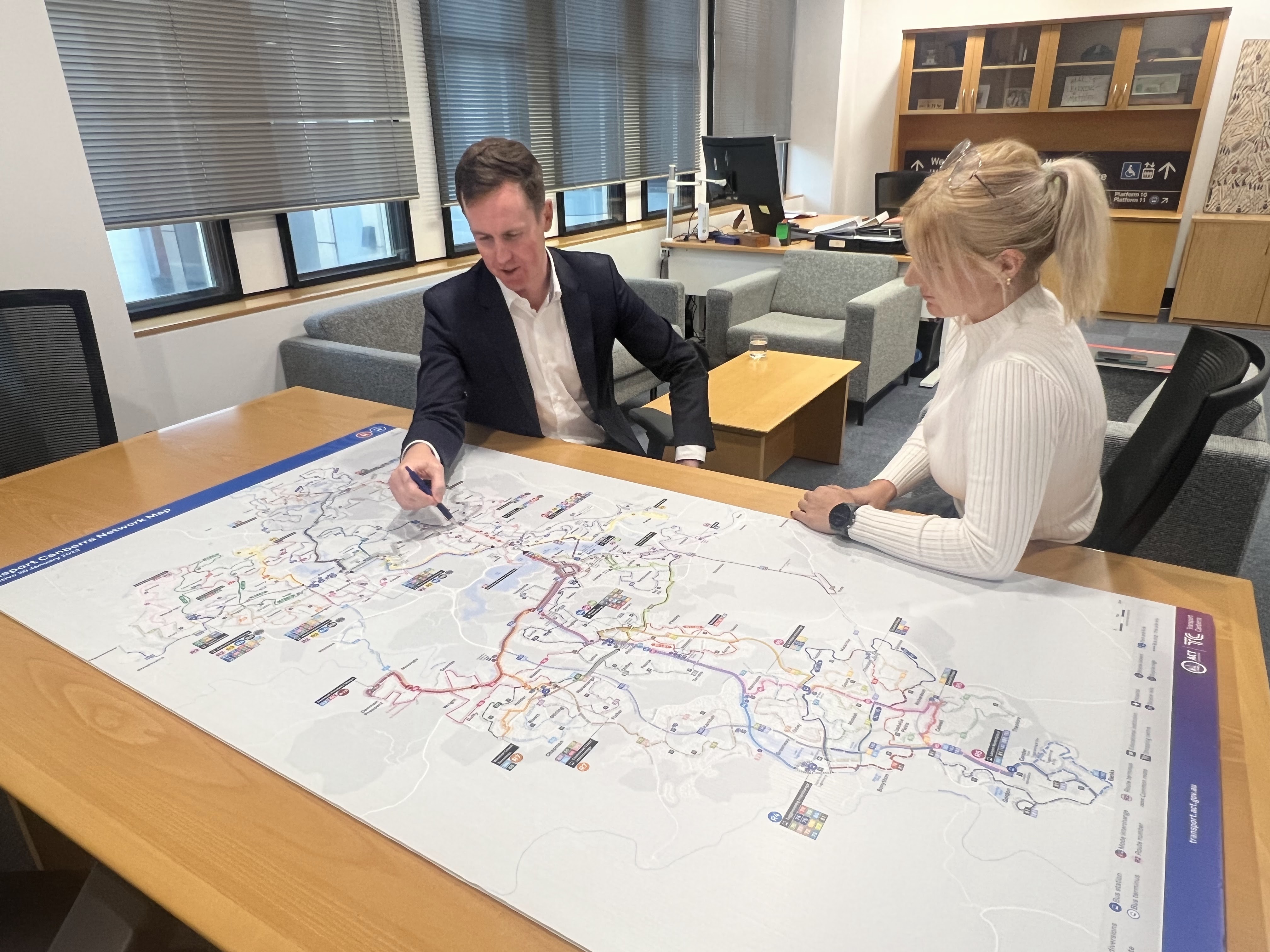 Two people looking at a bus route map.