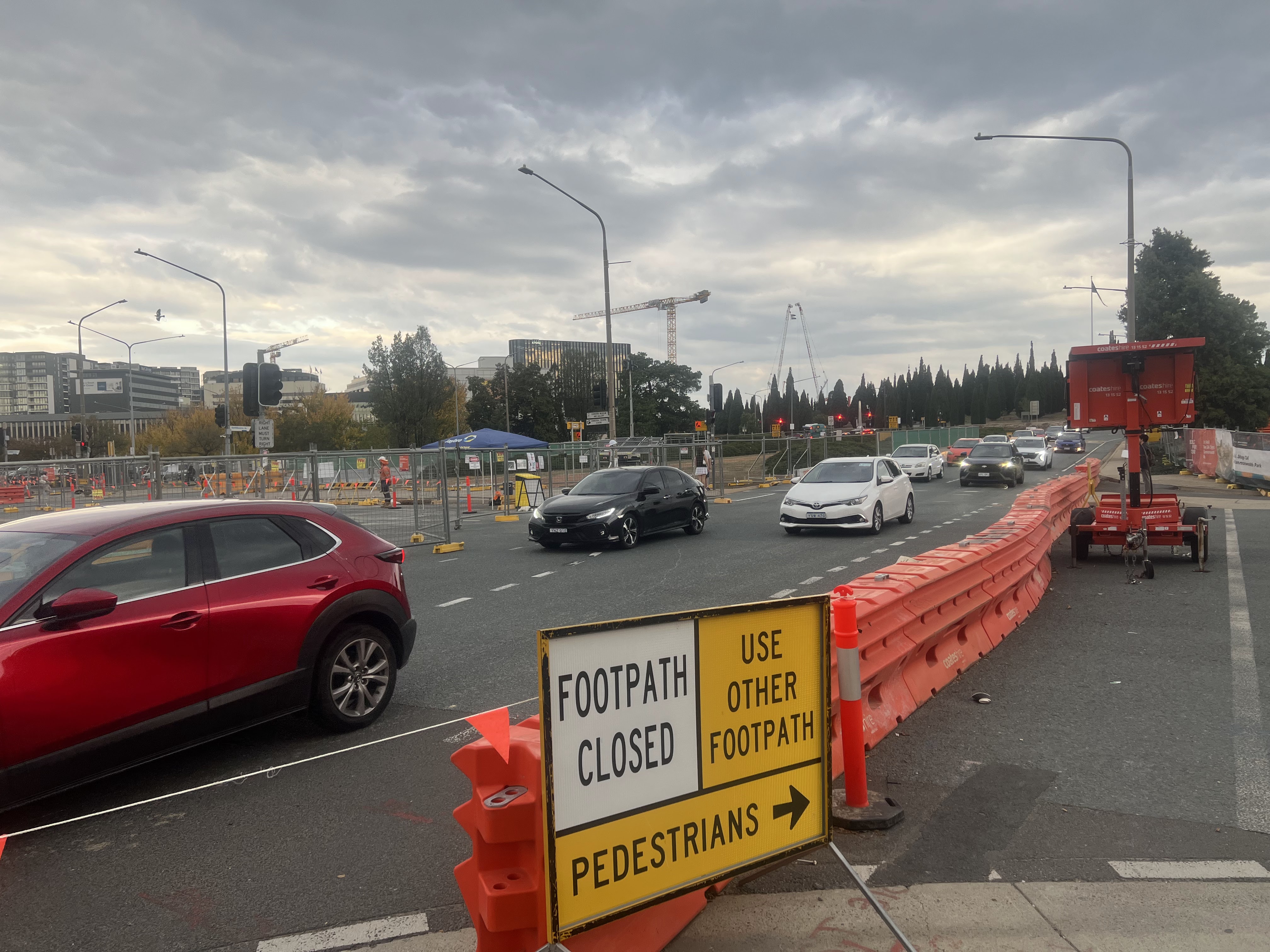 Cars driving past construction work.