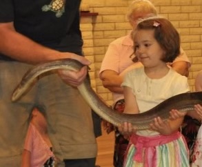 Mia as a young child, holding a snake 