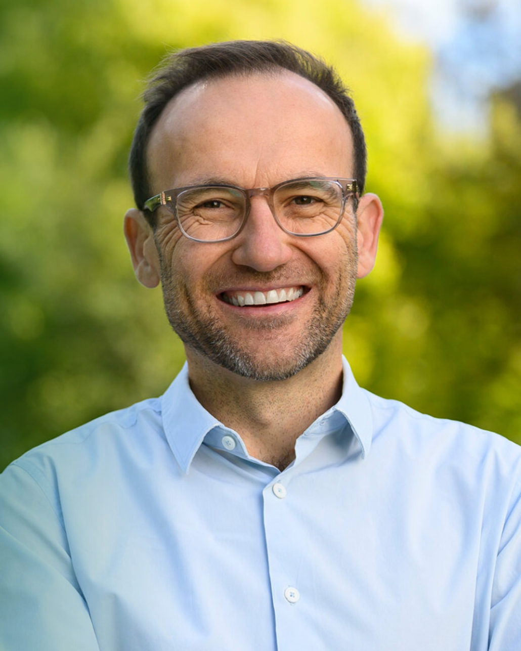 A portrait photograph of Adam Bandt smiling