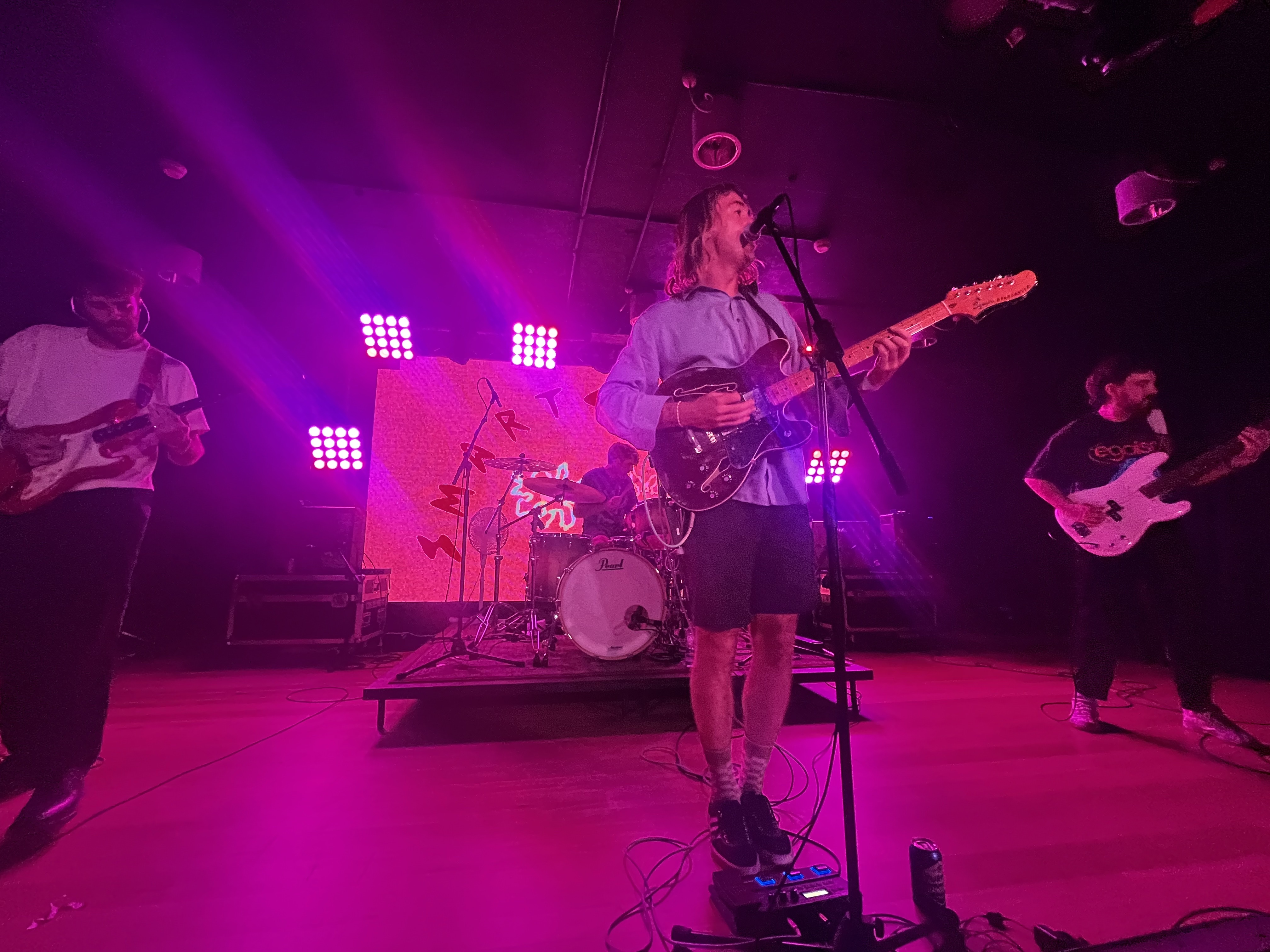 Surf rock band plays in front of crowd.