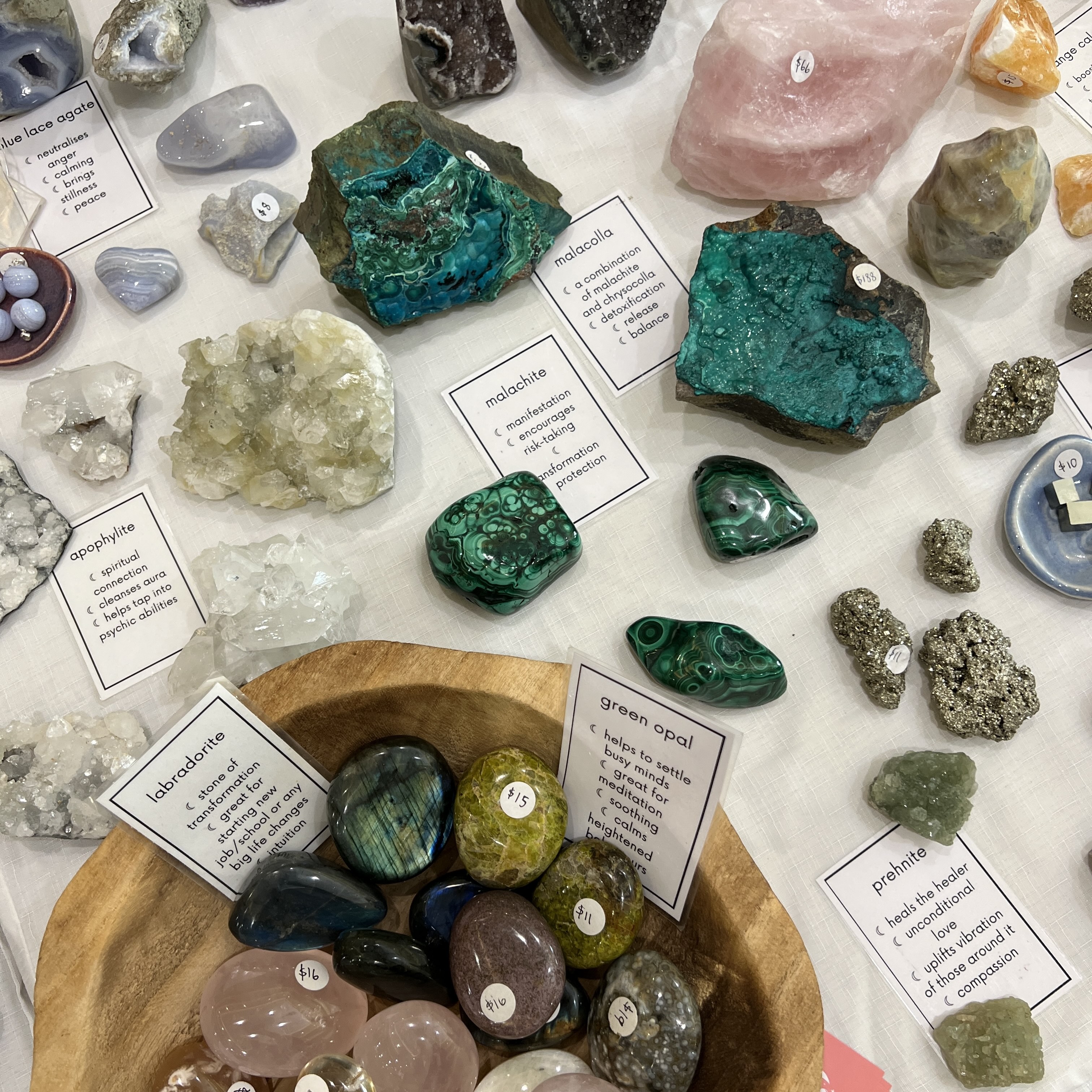 Different colour crystals on white table with cards explaining their healing properties