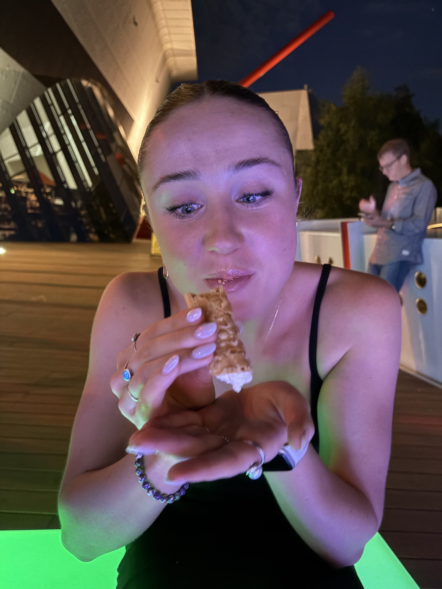Photograph of Hetta holding a cannoli, staring at it