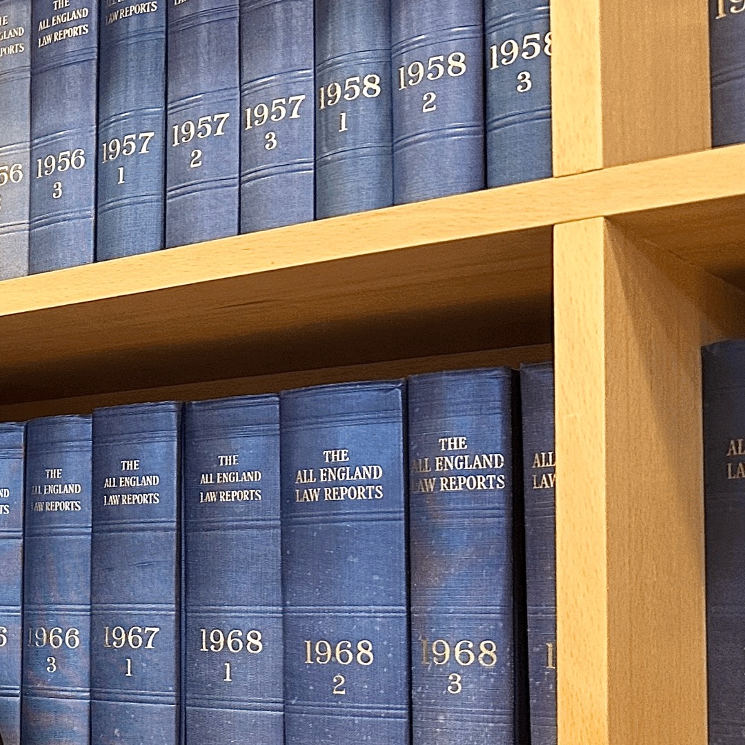 Bookshelf lined with multiple blue-spined copies of the 'All England Law Reports'.