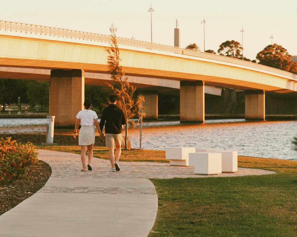 A photograph of two people walking around Lake Burley Griffin, Canberra
