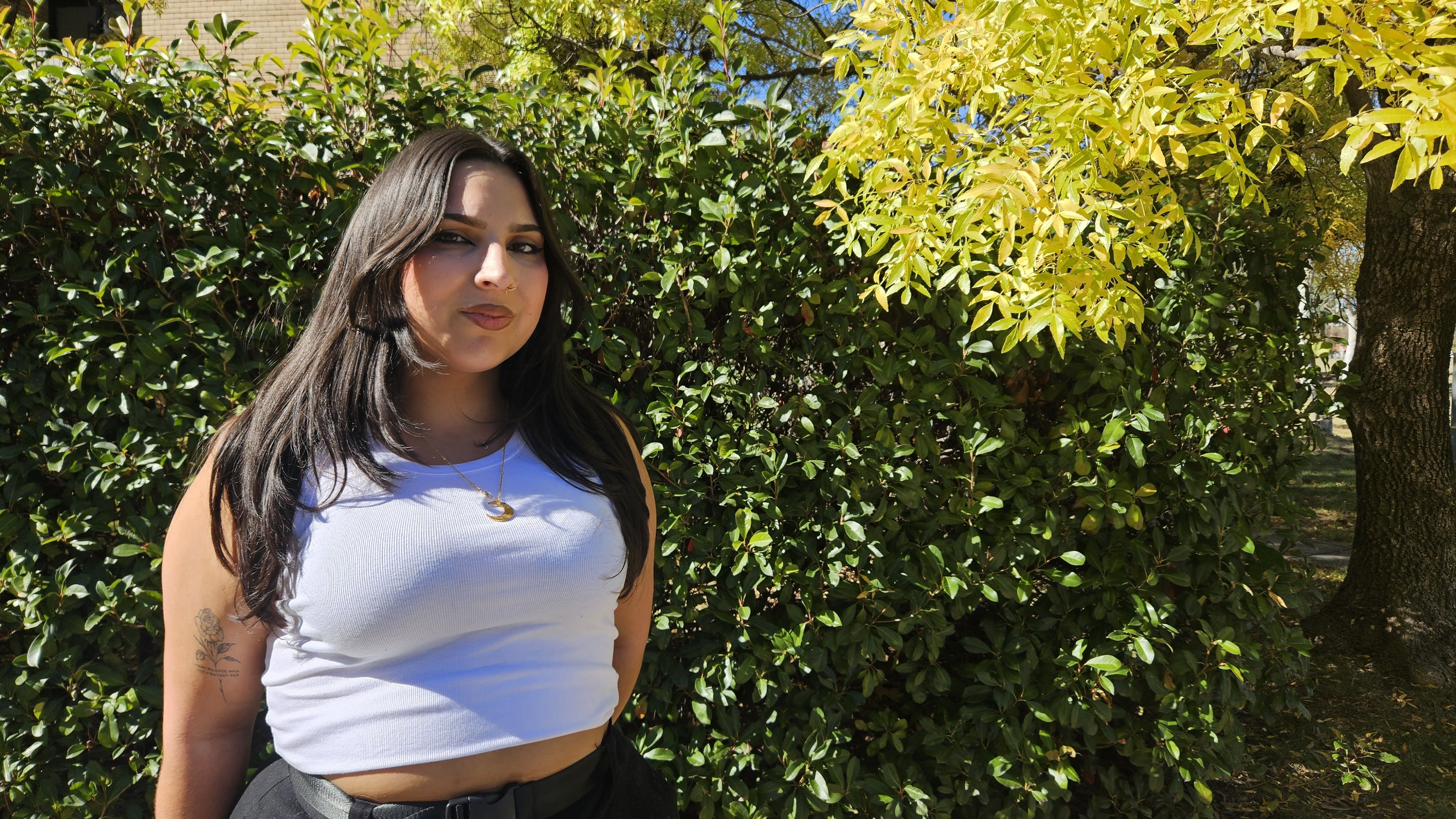 Jazmeen with greenery behind her.