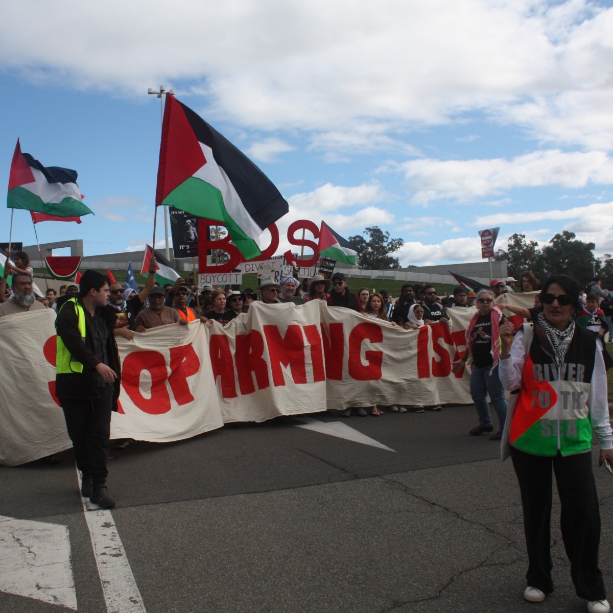 Pro-Palestine protesters walking past Australian Parliment House.