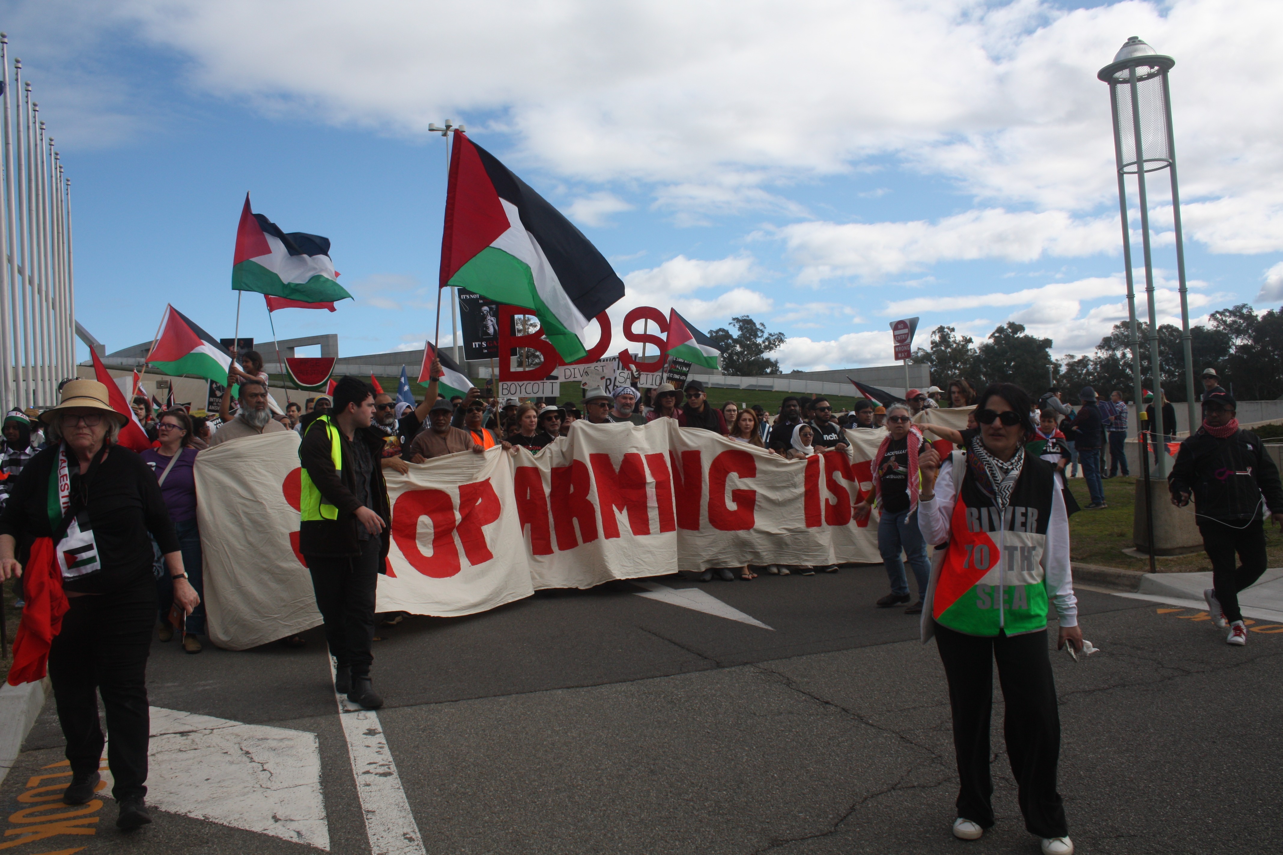 Pro-Palestine protesters walking past Australian Parliment House.