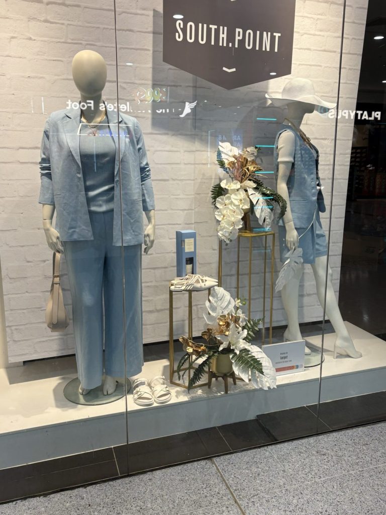 Photograph of mannequins wearing a light blue oversized jacket,