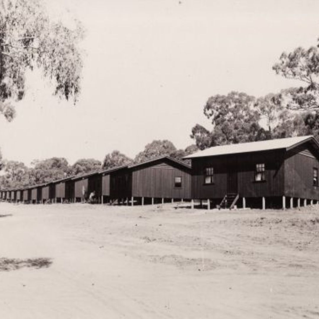 A line of simple timber cottages.
