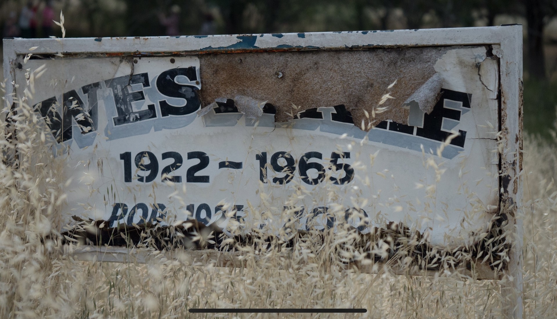 A dilapidated sign with paint peeling off reads 'Westlake: 1922-1965'
