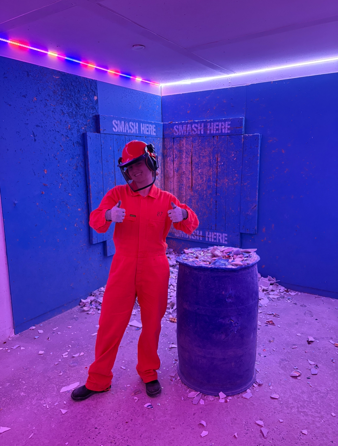 Me standing inside Breakr rage room, smiling and giving a thumbs up
