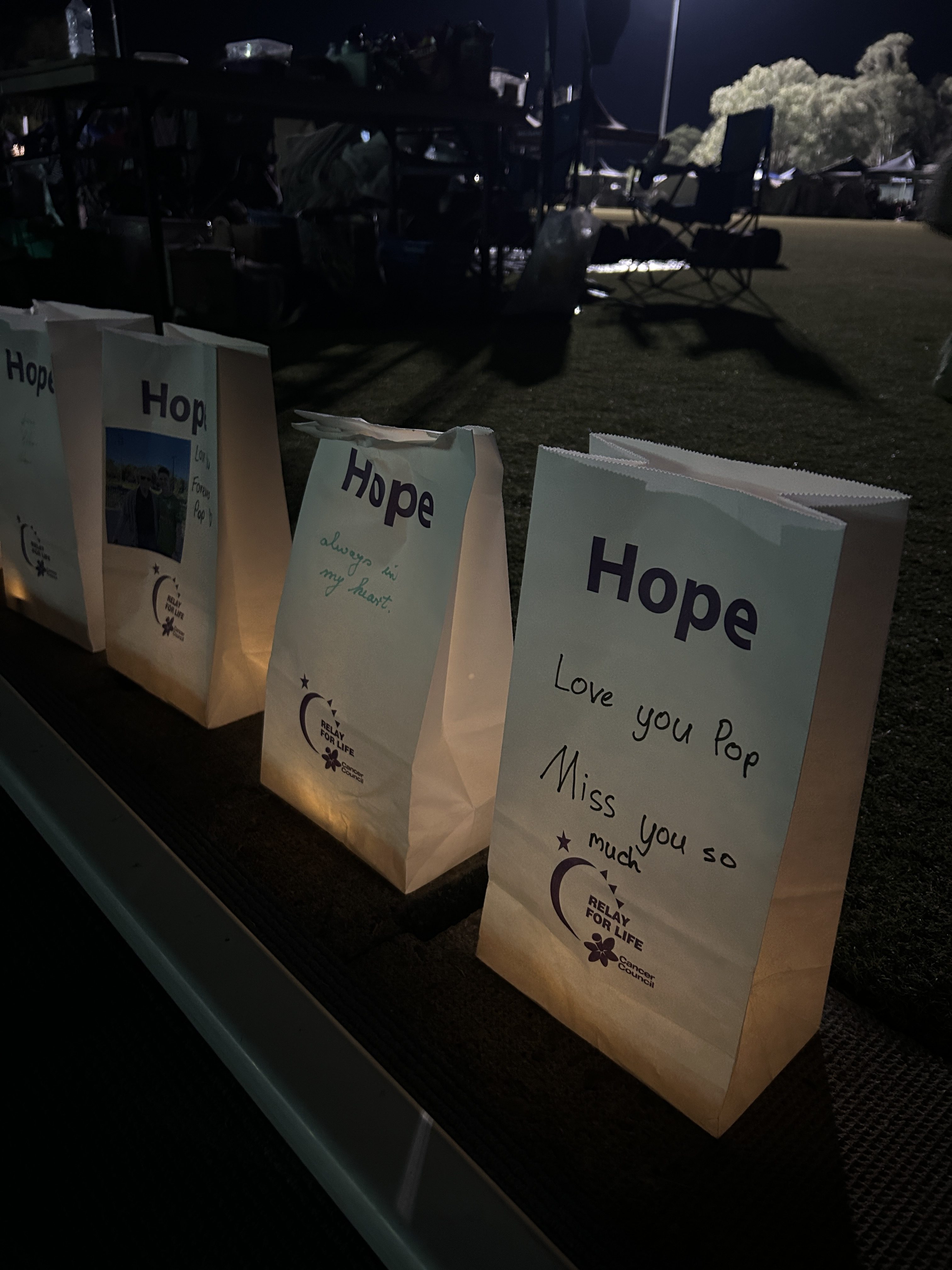 Candlelit paper bags reading 'hope'.