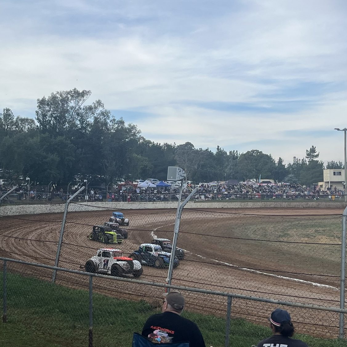 Multiple legend cars racing around the track at ACT speedway.