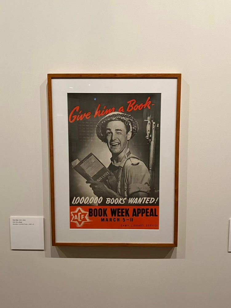 A poster of a WW2 soldier. It is calling for contributions to a book drive in support of Australian soldiers